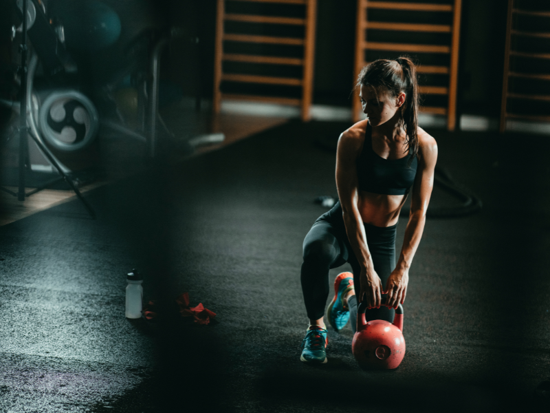 A fit woman rests during a strength training program after a kettlebell swing exercise—Body360 Fit Beverly Grove Los Angeles