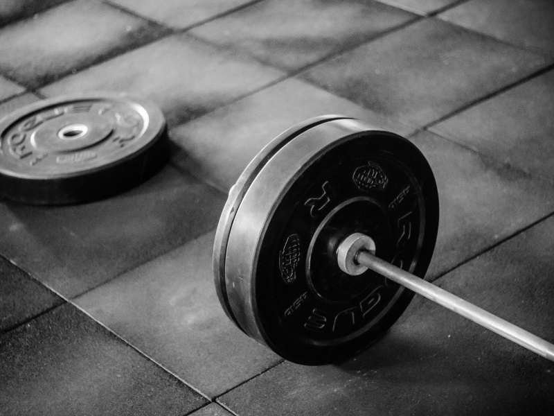 A barbell with weight plates is setup as a part of a strength training program.